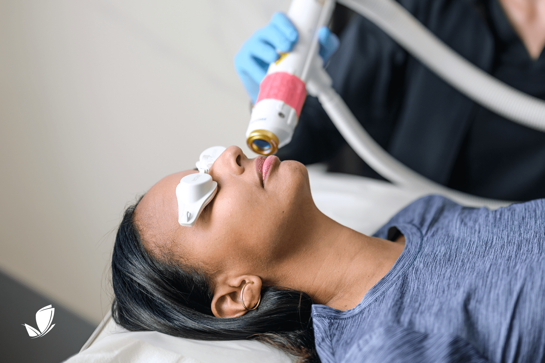 young woman wearing protective googles getting an Aerolase skin treatment. White LightRx butterfly in the left corner.