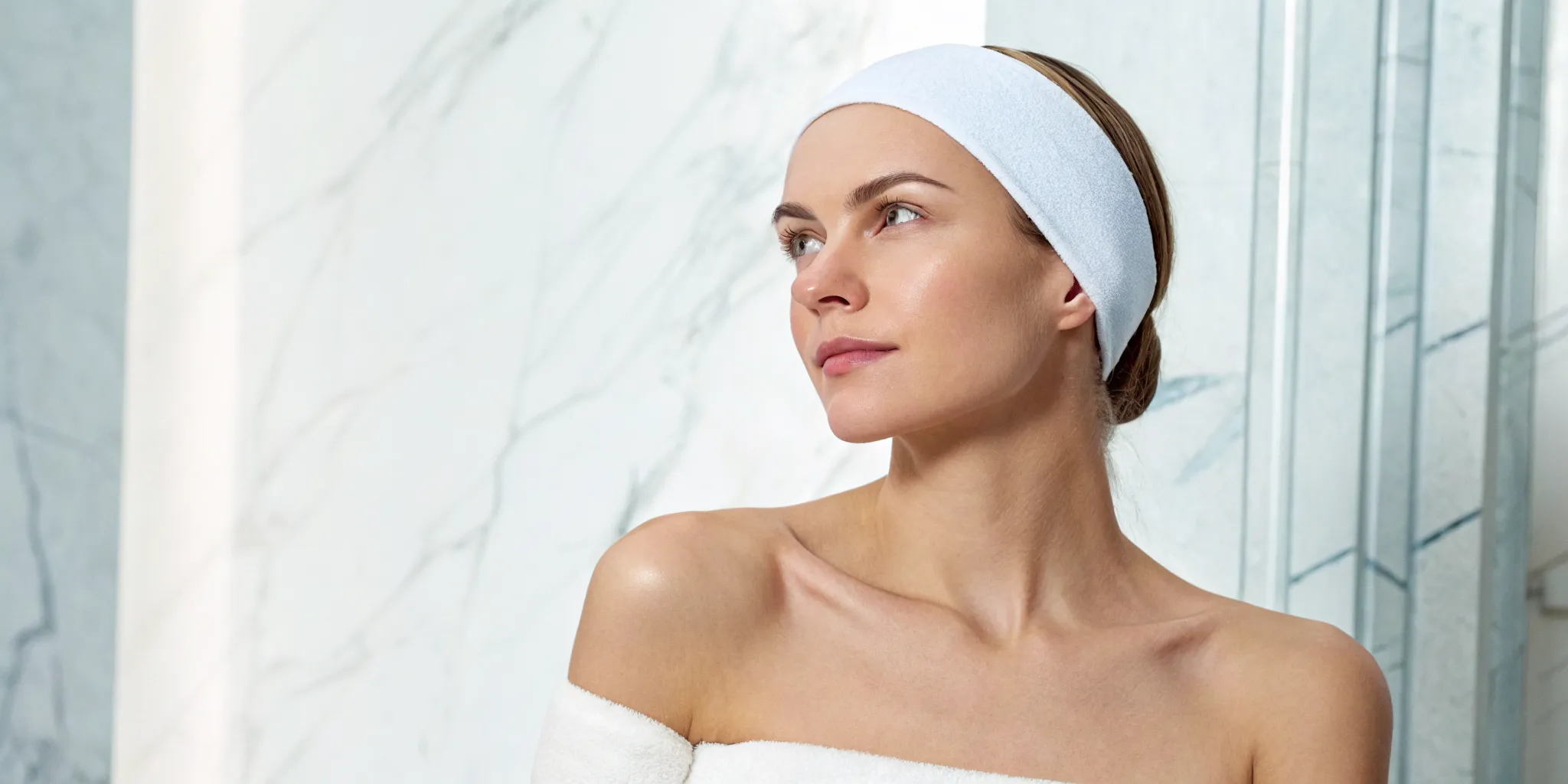 Woman in a spa deciding between microneedling vs a chemical peel for her skin concerns.